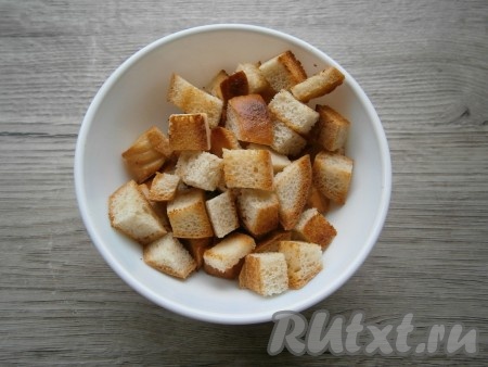 На сухую сковороду выложить батон или хлеб, нарезанный небольшими кубиками, и подсушить, иногда помешивая, до состояния сухариков, остудить.
