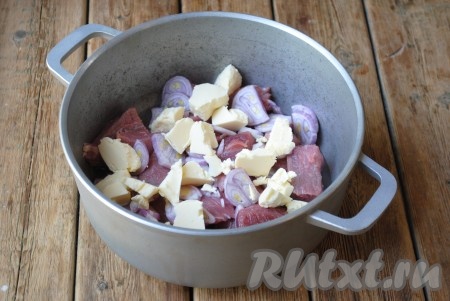 Сливочное масло нарезать кусочками и выложить поверх лука.
