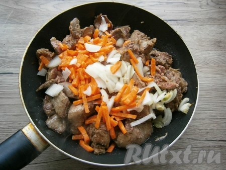 В разогретую с растительным маслом сковороду выложить куриную печенку, обжарить ее со всех сторон на среднем огне до легкой румяности. Далее добавить в сковороду нарезанный кусочками репчатый лук и нарезанную брусочками морковь.

