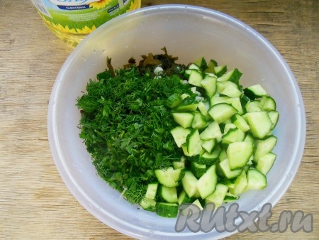 В миске соединить морскую капусту, зелень, зелёный лук и огурцы, влить растительное масло. Так как маринованная морская капуста уже солёная, соль я не добавляю, но вы можете посолить по вкусу.