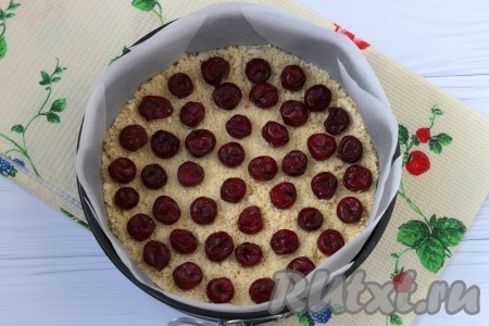 Форму 22 см застелить пергаментом и насыпать половину крошки из муки и масла. Если у вас есть ягоды, то разложите их поверх крошки в произвольном порядке.