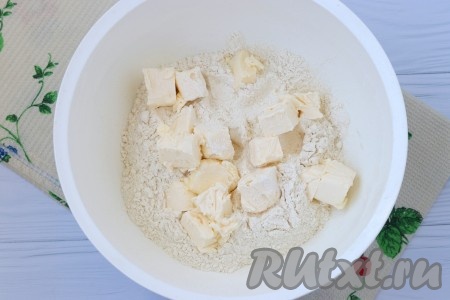 В миску просеять муку вместе с разрыхлителем, добавить нарезанное кусочками сливочное масло.