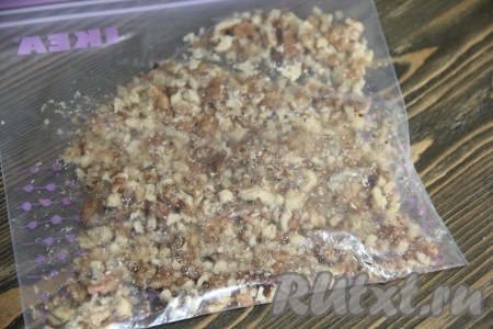 Орехи поместить в пакет и измельчить в крупную крошку, тоже с помощью скалки. Можно измельчить печенье и орехи в блендере.
