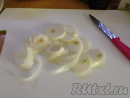 Лук чистим, моем и нарезаем кольцами. Затем выкладываем слой лука в емкость для запекания.