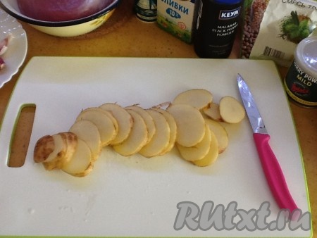 Картошку тщательно моем и нарезаем тонкими колечками вместе с кожурой. Выкладываем поверх лука, солим и посыпаем ароматными травками по вкусу.