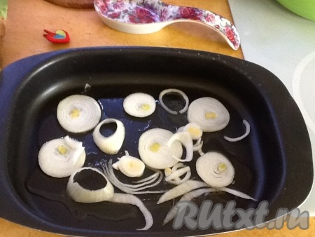 Лук чистим, моем и нарезаем кольцами. Затем выкладываем слой лука в емкость для запекания.