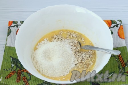 В смесь кефира, яйца и масла добавить соду, перемешать, всыпать муку и овсяные хлопья, перемешать тесто.
