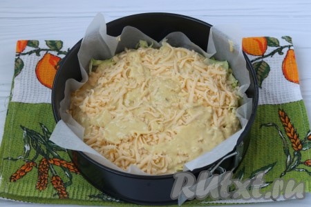 Форму диаметром 22 см застелить пергаментом, вылить половину теста, затем выложить капусту, посыпать натертым сыром и вылить оставшееся тесто.
