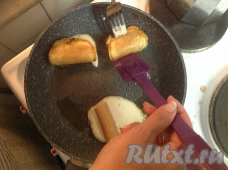 Теперь аккуратно с помощью лопатки и вилки (как на фото) сложить кружок теста пополам, придавая ему форму красивого конвертика (благодаря складыванию оладушка пополам с помощью лопатки и вилки, вытечет меньше теста).