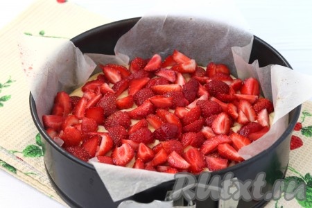 Клубнику моем, просушиваем и разрезаем на четвертинки. Застилаем форму для выпечки пергаментом, выливаем тесто, а сверху раскладываем клубнику. Форма у меня диаметром 22 см, можно взять диаметром 24-25 см.
