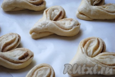 Таким образом сформировать все плюшки с сахаром и корицей, выложить их на противень, застеленный пергаментом. Накрыть полотенцем и оставить на 15-20 минут в тёплом месте.&nbsp;
