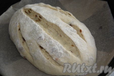 Переложить батон на противень, застеленный пергаментом. Сделать острым ножом глубокие надрезы. Оставить батон на 45 минут под полотенцем.
