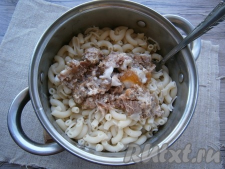 Макароны откинуть на дуршлаг, дать стечь воде и вернуть их обратно в кастрюлю. Добавить тушенку.
