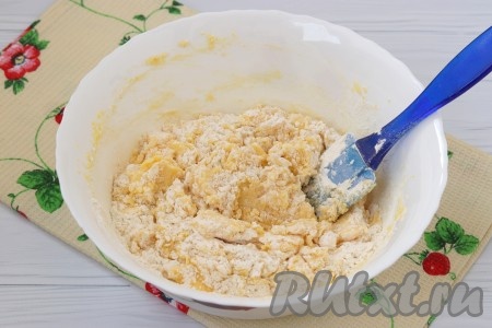 В тесто добавить просеянную муку и аккуратно перемешать лопаткой.