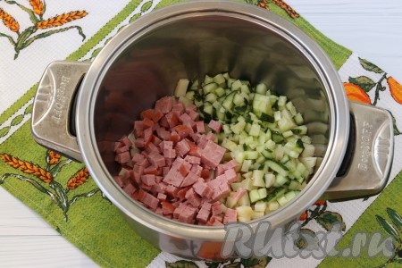 Очистить варёный картофель, нарезать кубиками. Также нарезать колбасу и огурцы. Некоторые хозяйки очищают огурцы от шкурки, но я думаю, это нужно делать только в тех случаях, когда шкурка достаточно грубая. Сложить нарезанные картофель, огурцы и колбасу в кастрюлю.