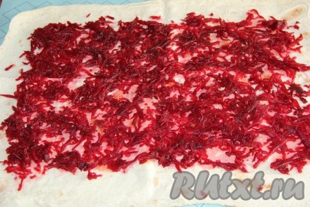 Картошку и морковь вымыть, не очищая от кожуры, поместить в кастрюлю, залить полностью водой, поставить на огонь, варить с момента закипания на небольшом огне до готовности овощей (на варку моркови с момента закипания потребуется минут 35, картошки - минут 25). В отдельной кастрюле отварить до готовности свеклу, не очищая её от кожуры (на варку может потребоваться 50-70 минут). Для того чтобы проверить готовность овощей, проколите их вилкой, если вилка входит легко, значит корнеплоды готовы. Готовые варёные картошку, морковь и свеклу выложить на тарелку, дать полностью остыть. На стол выложить первый лист лаваша. Свеклу очистить, натереть на крупной тёрке, выложить на лист лаваша и разровнять, оставляя 1,5-2 сантиметра от краёв лаваша чистыми.&nbsp;