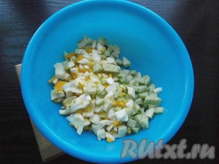 Свежий огурец очистить от кожицы, нарезать на небольшие кубики и выложить в миску. Добавить к огурцам очищенные яйца, нарезанные на кубики такого же размера.