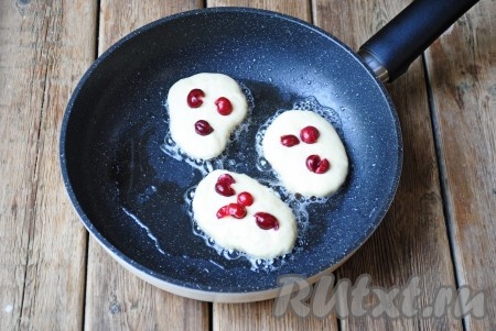 Сковороду разогреть с небольшим количеством растительного масла и с помощью столовой ложки выложить тесто, формируя оладьи. Сразу же в центр выложить по несколько ягод. 