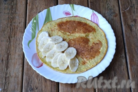 Готовый блин переложить на блюдо. Оставшуюся половину банана выложить на одну половину блина, накрыть второй половиной блина.