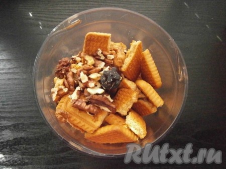 Печенье поломать на части, поместить в чашу блендера вместе с ядрышками грецких орехов.