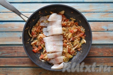 Филе рыбы нарезать небольшими кусочками, выложить в сковороду к тушеной капусте, накрыть крышкой и продолжить тушение еще 7-10 минут. Периодически необходимо аккуратно перемешивать содержимое. Если рыба не очень сочная, можно влить немного воды или томатного сока.