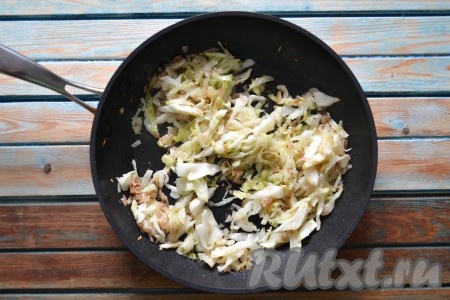 Влить 2-3 столовые ложки воды и, помешивая, обжарить капусту до мягкого состояния на слабом огне. Капуста должна стать прозрачной и начать поджариваться (на это уйдет, примерно, 7-10 минут).
