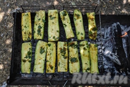 Когда кабачки замаринуются, выложить их на решетку и отправить на мангал. Готовить их нужно над раскаленными углями, а не над языками пламени. Это важно, иначе кабачки обуглятся за считанные минуты и будет безнадежно утрачен и вкус, и вид блюда. 