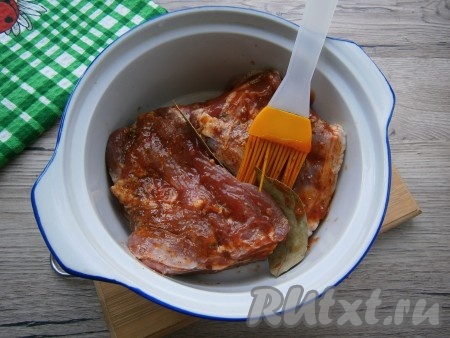 В кастрюльку, пригодную для приготовления в микроволновой печи, выложить свинину, смазать верх томатным соусом, между кусками мяса разместить лавровые листья.
