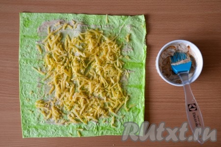Щедро посыпать сыром, смазанную часть лаваша (то есть края лаваша оставить без сыра и соуса).
