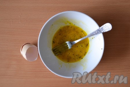 В миске взбить куриное яйцо, добавить щепотку соли и прованские травы. 