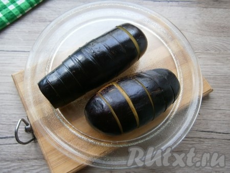 Баклажаны обмыть проточной водой, обсушить, поместить на тарелку из микроволновки. Запекать баклажаны в микроволновой печи 3 минуты на мощности 750 Ватт.&nbsp;
