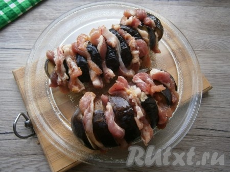 В каждый разрез баклажанов вложить по кусочку бекона.
