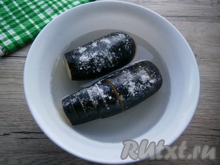 Поместить баклажаны в хорошо подсоленную холодную воду, придавить гнетом и оставить на 40 минут.
