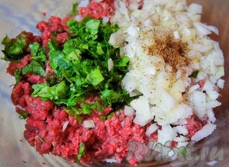 К фаршу добавить мелко нарезанный репчатый лук, зелень, соль, перец, измельчённую зиру, перемешать.
