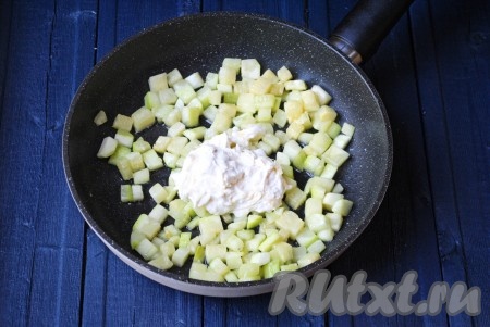 Выложить сметанно-сырный соус на сковороду к обжаренным кабачкам, влить воду, хорошо перемешать. По желанию, можно добавить измельчённый чеснок.