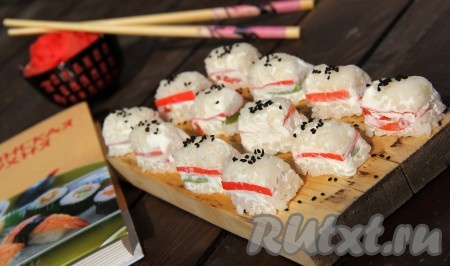 Таким образом заполнить все луночки. Перевернуть форму на плоскую тарелку и аккуратно снять плёнку. По желанию, готовые роллы с крабовыми палочками и огурцом посыпать кунжутом. Вот такие многослойные и очень нежные роллы получились. Подать с соевым соусом.&nbsp;
