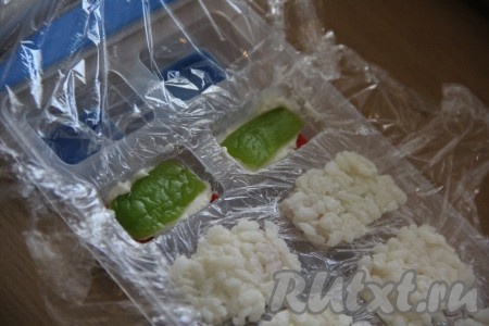 Огурчик предварительно нарезать тонкими полосками. Выложить кусочек огурца поверх сыра.
