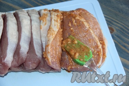 С помощью силиконовой кисти нанести маринад на свинину, тщательно смазывая кусочки мясной гармошки со всех сторон.
