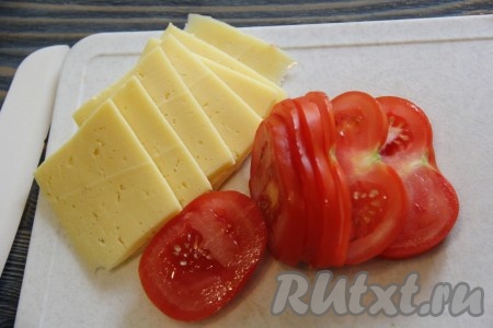 Помидорчики вымыть и нарезать кружочками. Сыр нарезать на тонкие кусочки.

