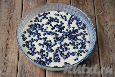 Форму для выпечки смазать сливочным маслом или застелить пергаментом и вылить тесто. Поверх теста равномерно распределить ягоды. 