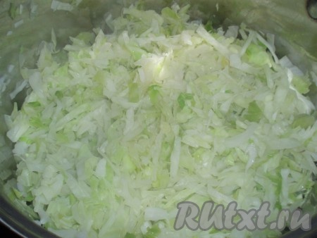 Капусту сложить в большую кастрюлю, влить неполный стакан воды и тушить, пока капуста не обмякнет и будет почти полностью покрыта жидкостью.