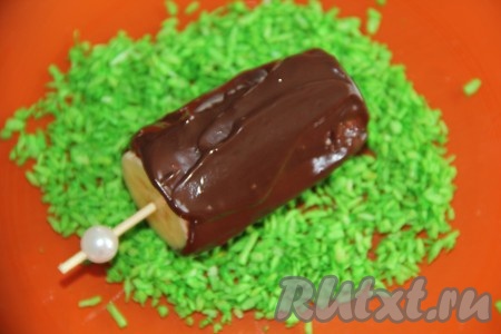 Обмакнуть бананы в растопленный шоколад так, чтобы они полностью покрылись равномерным слоем шоколада. Это удобно делать, держа банан за палочку. Затем шоколадное "эскимо" обвалять в кокосовой стружке. Переложить бананы в шоколаде на разделочную доску и убрать в морозилку еще на 30 минут.
