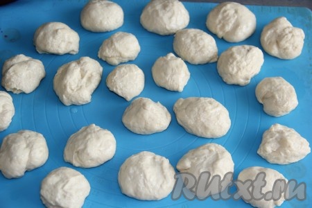 Затем поднявшееся тесто, замешанное в хлебопечке или вручную, обмять и разделить на кусочки величиной с большой грецкий орех. Оставить тесто на столе на 20 минут, прикрыв полотенцем.&nbsp;