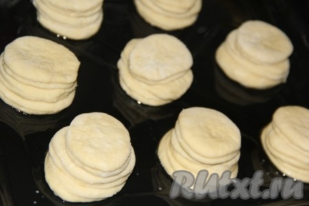 Противень для выпекания смазать растительным маслом. Выложить кружочек теста, с помощью силиконовой кисти слегка смазать верх кружочка водичкой, сверху выложить следующий кружочек, тоже слегка смазать водичкой и выложить третий кружочек. Аналогично из трёх кружочков сформировать и все остальные булочки.
