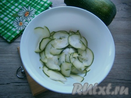 Молодой цукини (можно не очищать) обязательно нужно нарезать очень тонко. В этом поможет терка для шинковки капусты, терка Бернера или обычная овощечистка. Если нарезать цукини овощечисткой, получатся тоненькие слайсы. К тонко нарезанному цукини добавить соль, перемешать и оставить на 30 минут.