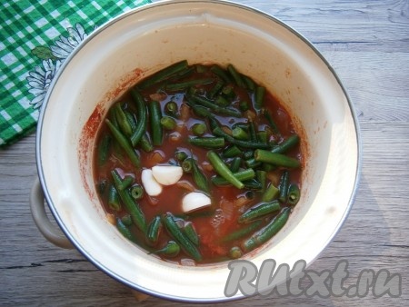 Сюда же добавить зубчик чеснока, разрезанный на 2-3 части, довести до кипения, уменьшить огонь.
