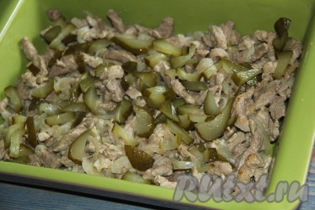Поверх мяса выложить огурцы.
