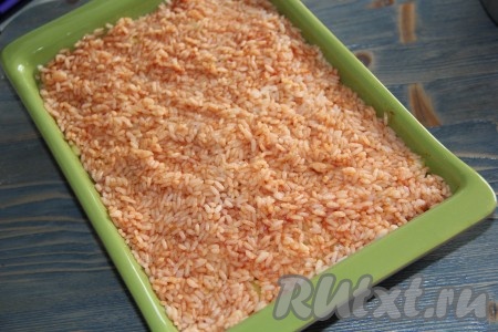 Выложить рис поверх мяса, разровнять и слегка утрамбовать.
