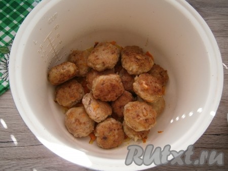 В чашу мультиварки выложить оставшиеся лук с морковью, сверху разместить обжаренные тефтели.