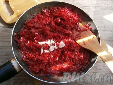 Перемешать содержимое сковороды, тушить овощи 4-5 минут, затем добавить нарезанный чеснок, перемешать и выключить газ. Томатно-свекольная заправка для постного свекольника готова.
